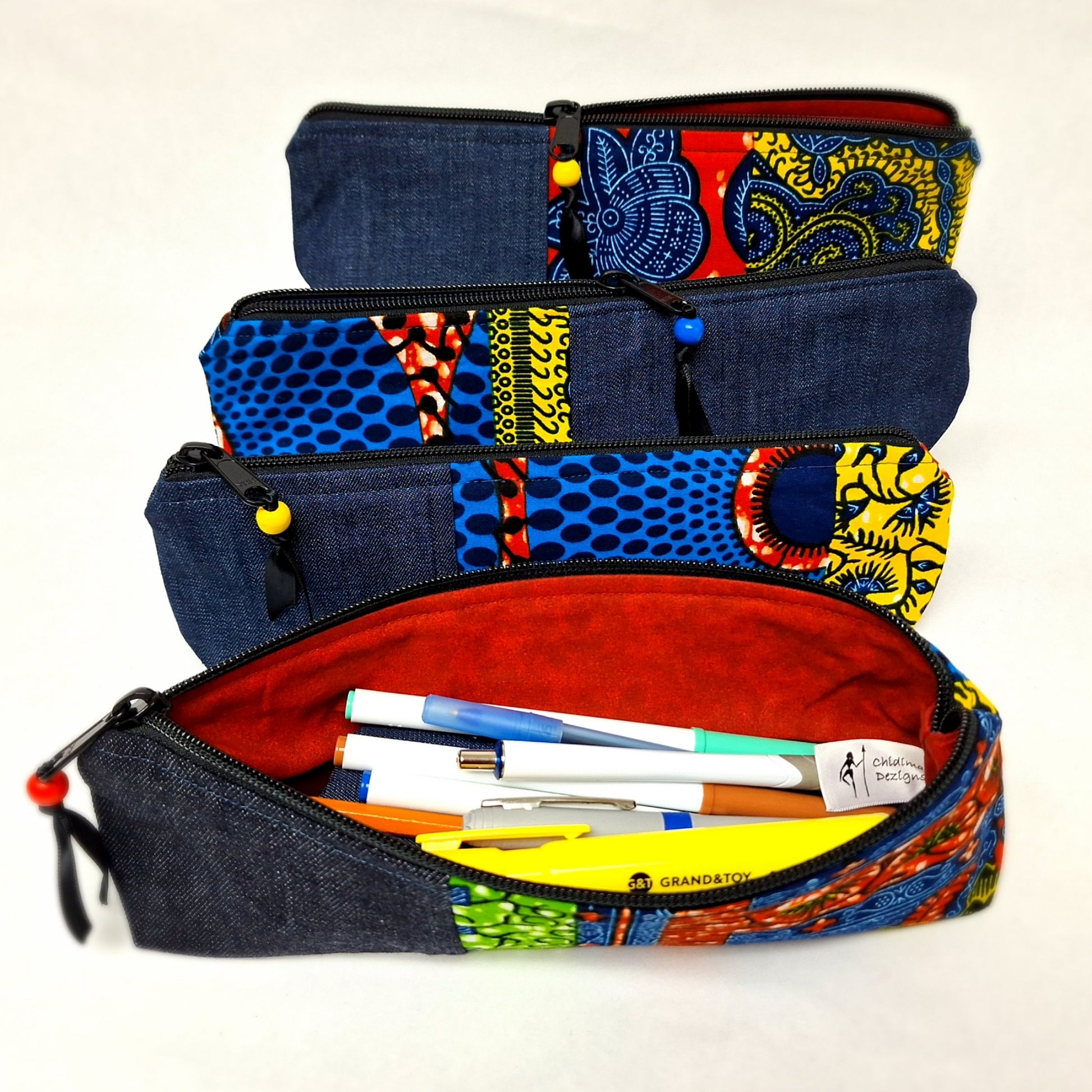 Slim zipper pouch made of bright African prints and denim.  Use it as a pencil case, make-up of whatever you wish. measure  approximately 11' long, 3" tall and 2" wide at the base. 